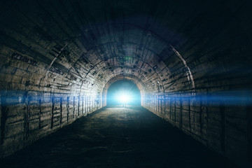 Light in end of tunnel. Long underground concrete corridor in abandoned bunker or nuclear shelter - obrazy, fototapety, plakaty