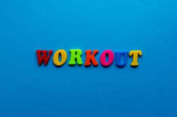 text workout  from plastic colored letters on blue paper background