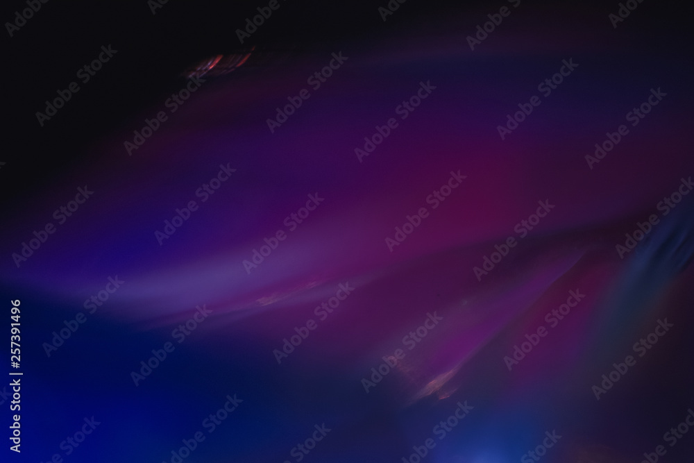 Wall mural blurred neon multicolor abstract lines on dark background. defocused lens flare glow effect.