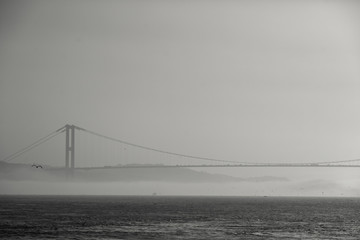 Photo of sea, bridge, cloudy sky.