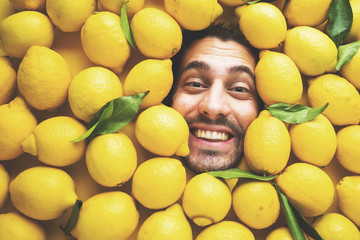 Mann mit Zitronen, Konzept für die Lebensmittelindustrie. Gesicht des lachenden Mannes in der...