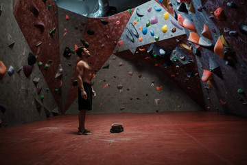 Athletic man practicing in a bouldering gym - obrazy, fototapety, plakaty