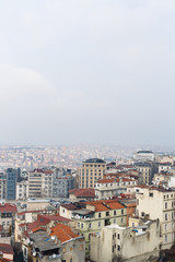Image from above of city with houses with red roofs in afternoon.