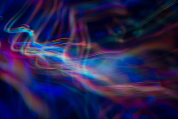 Fototapeta premium Blurry abstract background with wavy multicolor lines. Neon lights in motion. Defocused lens flare glow.