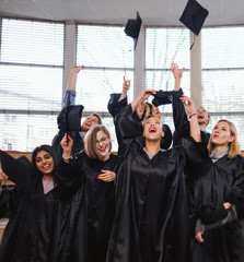 Multi ethnic group of graduated students throwing hats