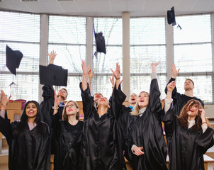 Obraz premium Multi ethnic group of graduated students throwing hats