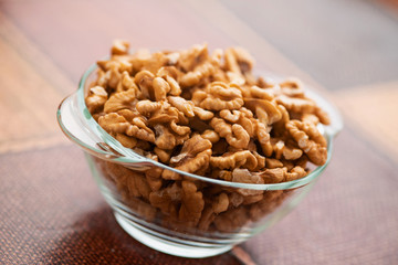 Studio photo of bowl with heap of peeled walnuts