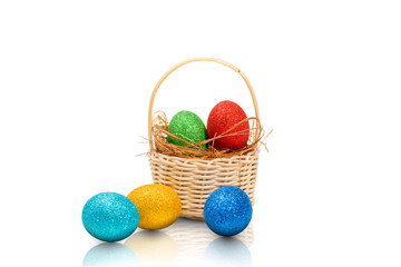 Colorful easter eggs with glitter in the nest on wooden basket