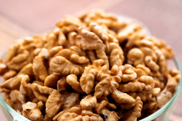 Studio photo of bowl with heap of peeled walnuts