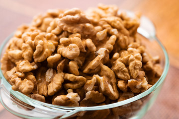 Studio photo of bowl with heap of peeled walnuts