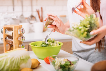 Obraz na płótnie Canvas Cooking hobby. Organic foods. Healthy female lifestyle. Women making green salad.