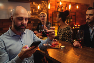 Man with cell phone behind bar counter in a cafe