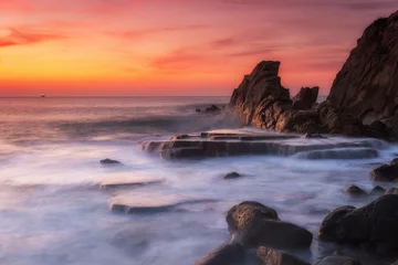 Gordijnen geweldig zonsonderganglandschap op rotsachtig strand © jon_chica