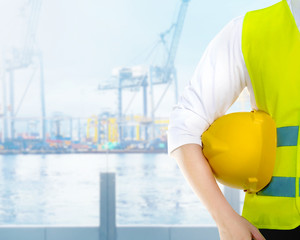 Male worker holding the yellow hard hat on his arms on the office