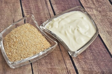 natural yogurt bran flakes in a glass cup on a wooden background