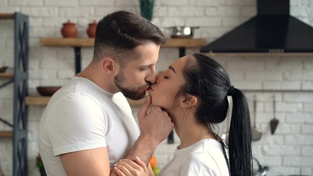 Portrait of couple in love kissing at the kitchen.