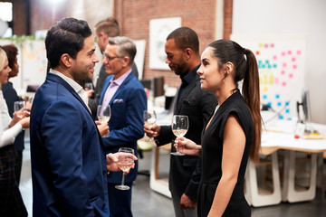 Business Team Socializing At After Works Drinks In Modern Office