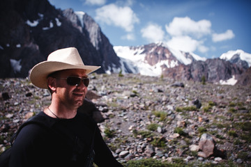 Portrait of a man in sunglasses and a hat with a walkie-talkie. Extreme trip to the mountains