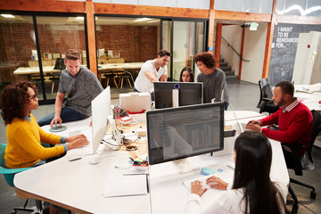 Fototapeta na wymiar Casually Dressed Business Team Working At Desks In Modern Open Plan Office
