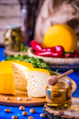Cheese wheel on a wooden board. Blurred background.
