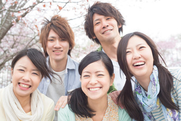 桜の前で微笑む若者たち