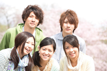 桜の前で微笑む若者たち