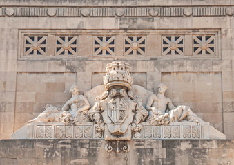 Pediment of old building is decorated with allegorical sculptures and bas-reliefs with  coat of arms of  Spanish king.