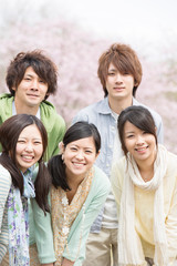 桜の前で微笑む若者たち