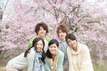 桜の前で微笑む若者たち