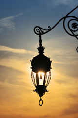 Fototapeta na wymiar Antique street lamp lantern over sunset sky