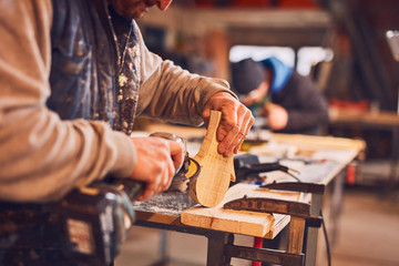 Male carpenter working on old wood in a retro vintage workshop.