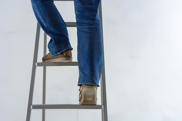 female legs are climbing the stairs against the background of the white plastered wall. repair of...