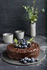 Holiday chocolate cake with cups on dark gray background