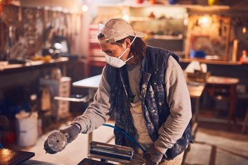 Male carpenter working on old wood in a retro vintage workshop.