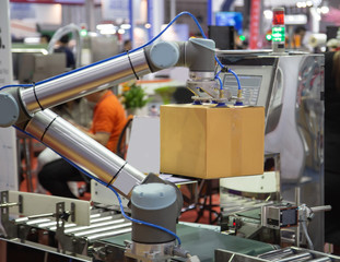 The universal robot lifting cardboard to conveyor in industry production line