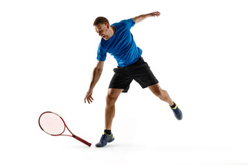 Stressed tennis player throwing and breaking a racket in anger and rage at court. Human emotions, defeat, crash, failure, loss concept. Athlete isolated on white