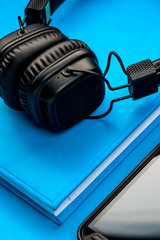 Black stylish headphones on blue background.