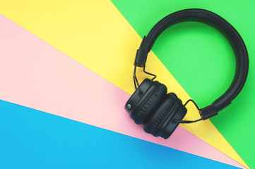 Black stylish headphones on colorful background