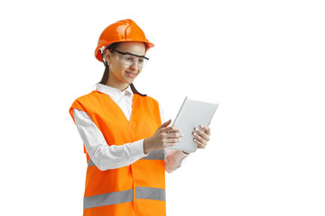 Destroying gender stereotypes. Female builder in orange helmet standing with laptop on white studio background. Safety specialist, engineer, occupation, businesswoman, job concept. Woman in the male