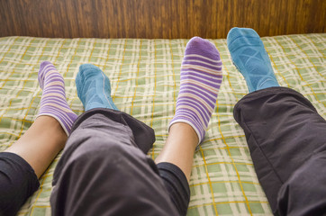  legs with socks of a couple in bed