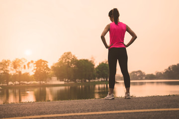 Fototapeta na wymiar Women warm up exercises before running jogging during sunset at road park