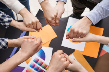 Group of people holding hands in office. Concept of unity