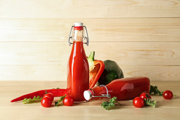 Bottles of vegetable smoothie on wooden table