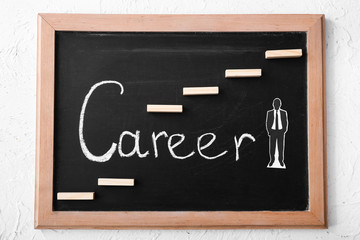 Chalkboard with human figure and word CAREER on table