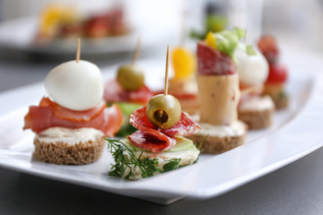 Tasty canapes on plate, closeup
