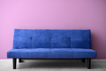Comfortable sofa near color wall