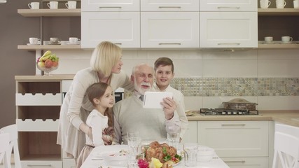Household Uses A Tablet For Video Communication During A Family Dinner