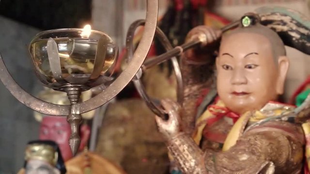 Oil lamp in chinese shrine. Close up of oil lamp burns hanging in front of altar table and god statue at Jui Tui shrine Phuket,hd slow motion.