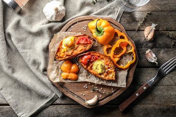 Baked sweet potato with egg on wooden board