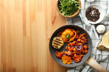Frying pan with prepared sweet potato on wooden table